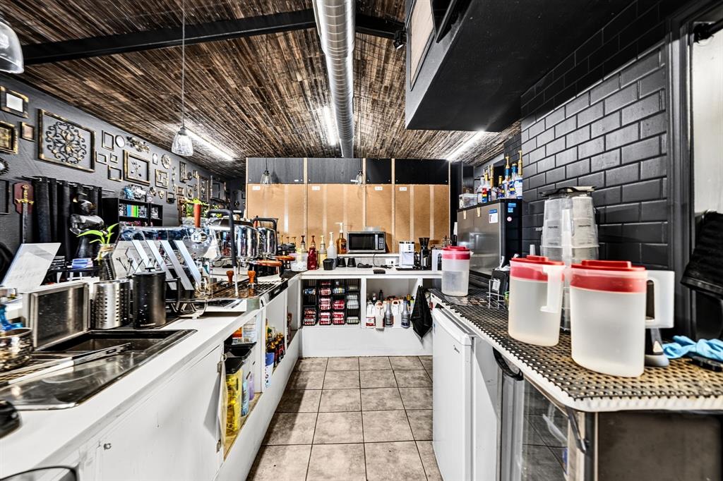 Service area featuring wood-plank ceiling, black subway tile backsplash, white built-in cabinetry, and tile flooring