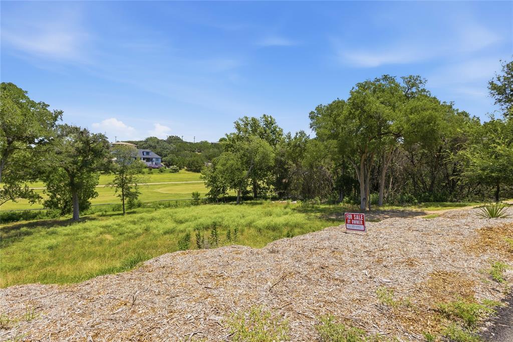 Expansive lot featuring mature trees, natural terrain, and direct topography overlooking a golf course