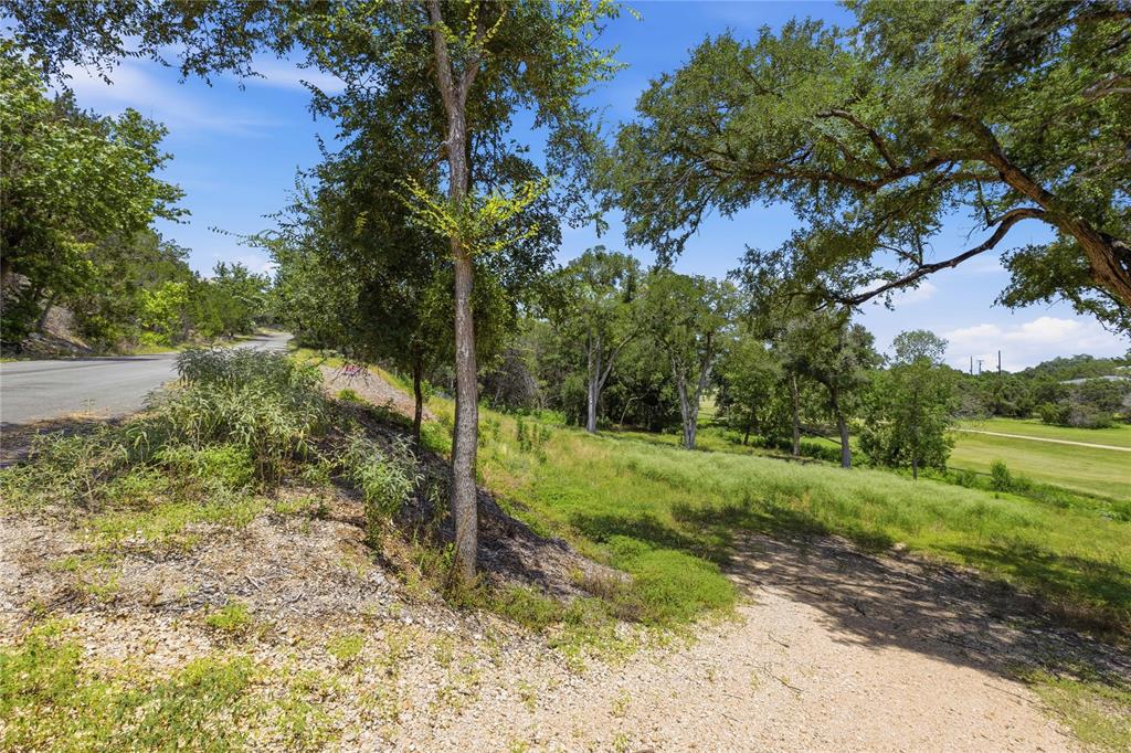 Expansive parcel featuring mature trees, a sloped topography, native landscaping, and paved road access