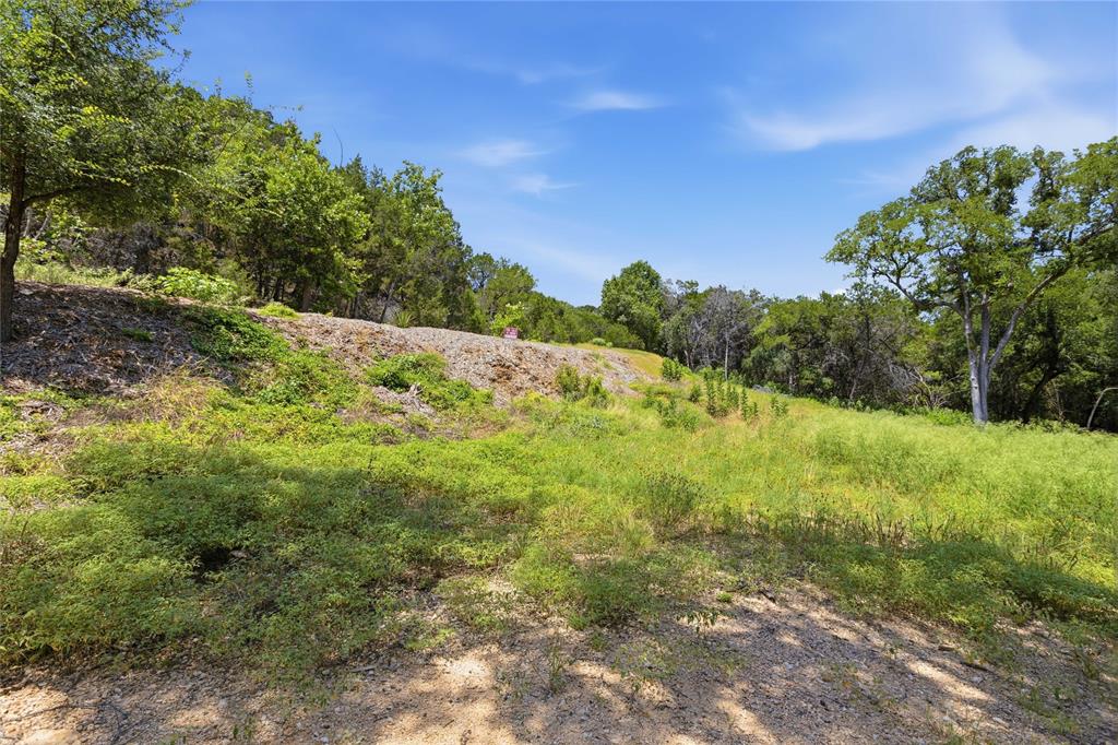 Sloped parcel featuring native vegetation, mature hardwood trees, and natural stone outcroppings