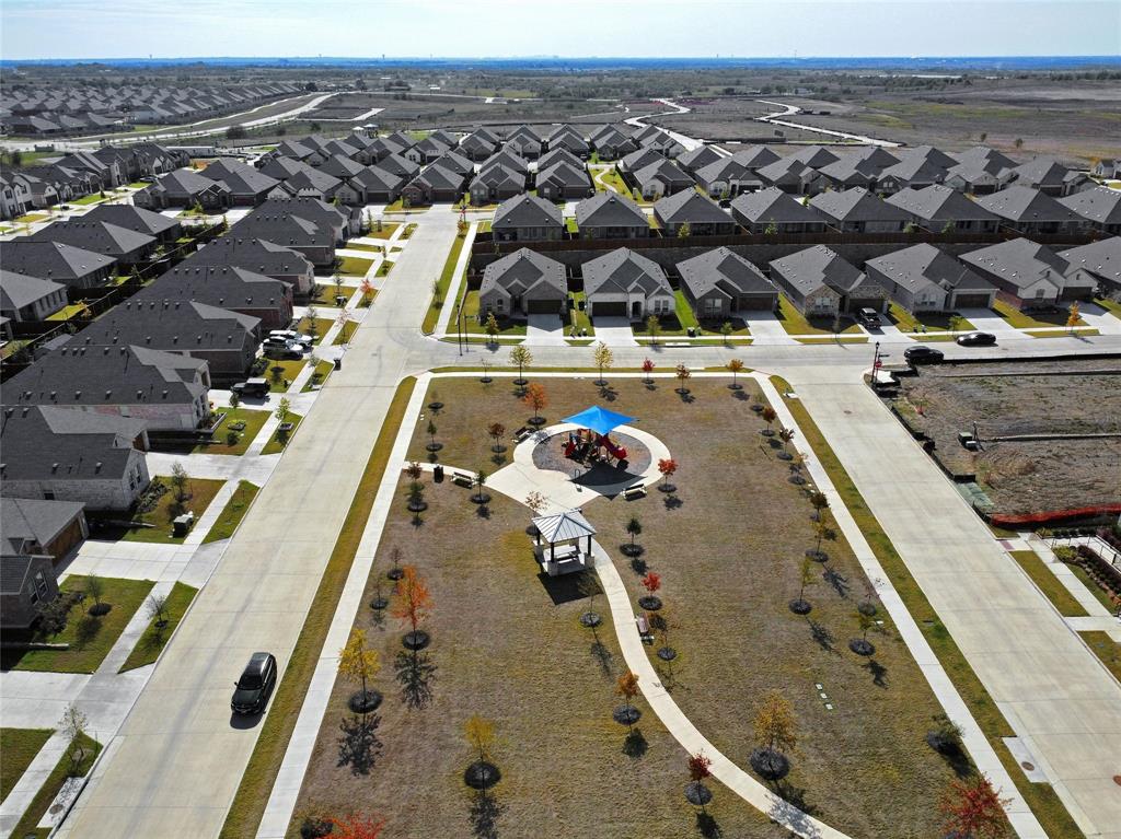 The house overlooks a community park, which features a central gazebo, paved walking paths, a shaded playground structure, and manicured landscaping