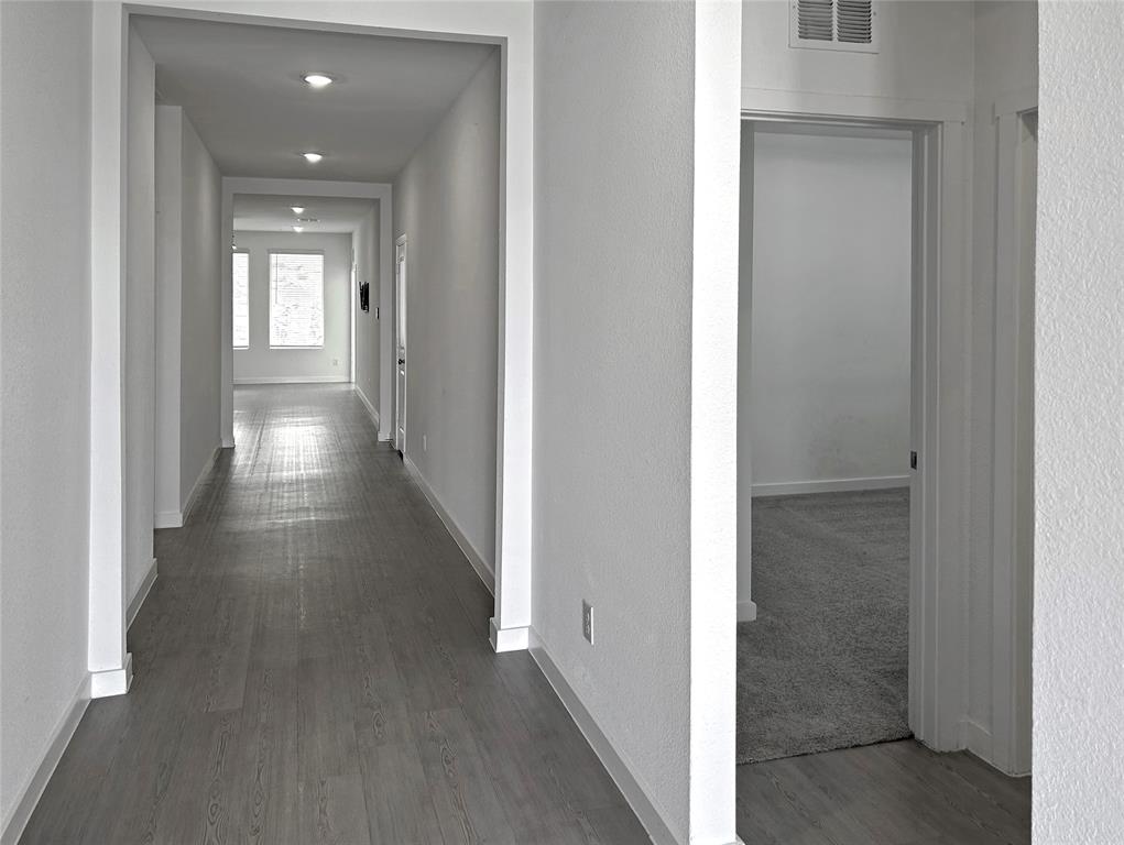 The entrance foyer features luxury vinyl plank flooring, recessed ceiling lighting, and neutral-toned wall paint