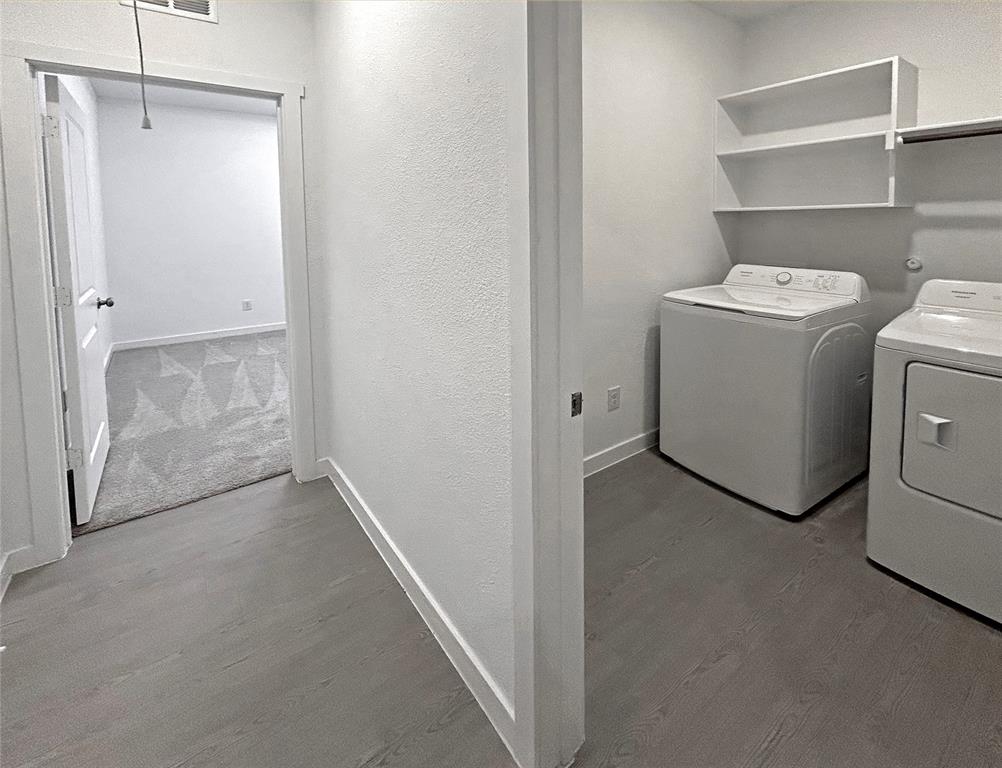 Laundry room featuring luxury vinyl plank flooring, built-in shelves, and white interior trim