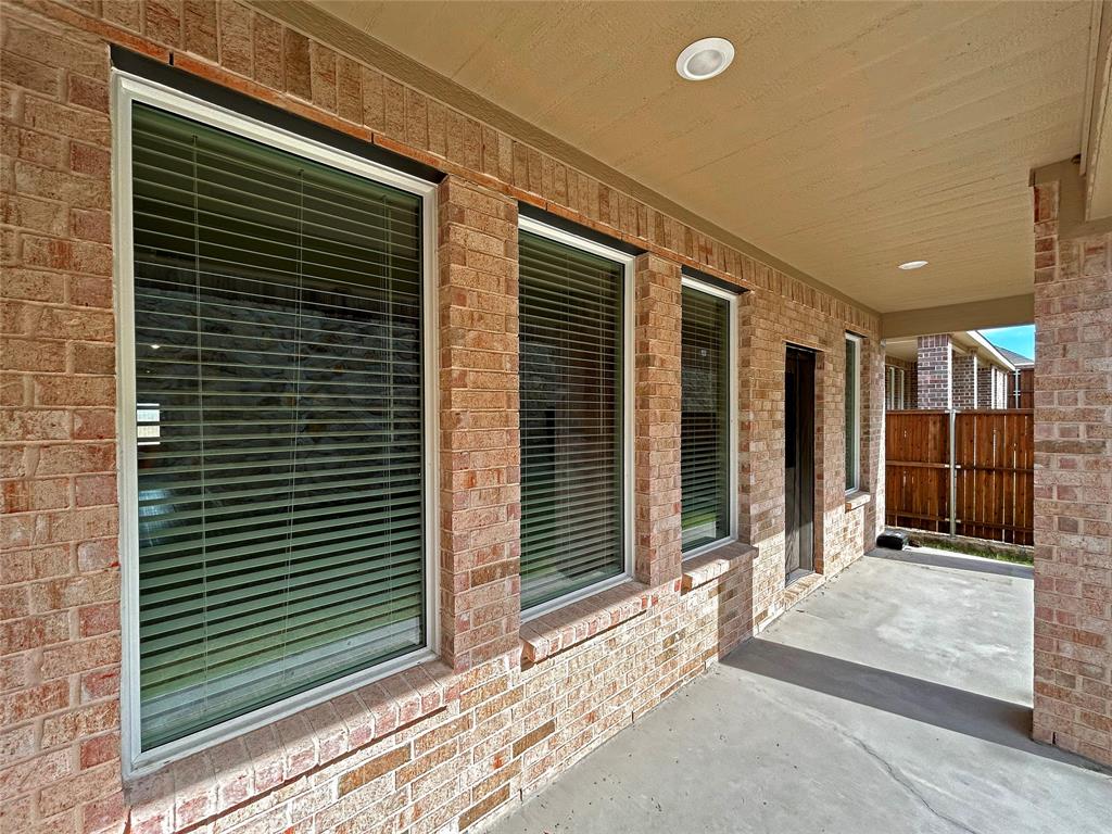 Covered patio featuring a concrete floor, recessed lighting, brick exterior walls, and multiple large windows