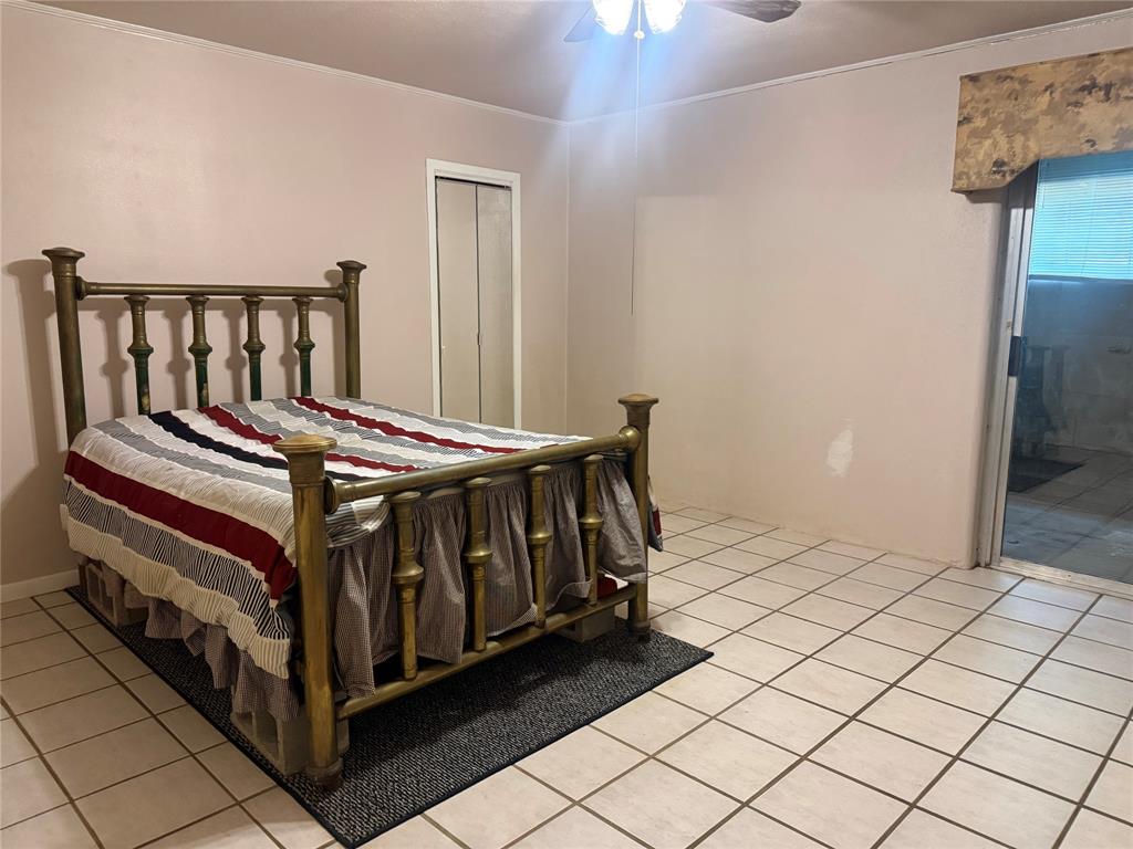 Ceramic tile flooring, built-in closet with mirrored doors, and ceiling fan with integrated lighting
