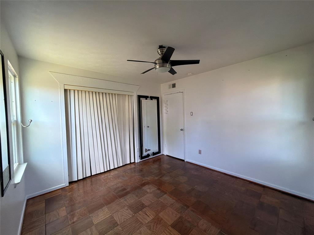 Parquet wood-finish flooring, ceiling fan with integrated lighting, and window casing