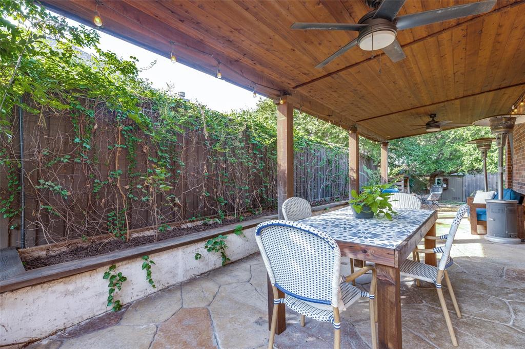 Covered patio featuring a wood-plank ceiling, ceiling fans, stamped concrete flooring, and a raised concrete planter bed
