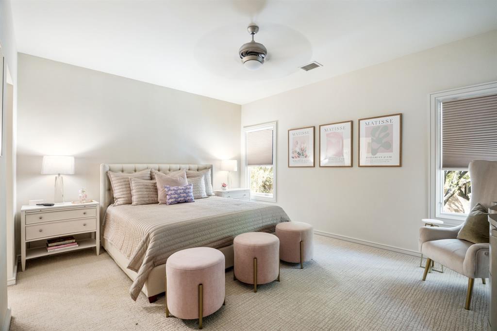 Neutral interior featuring high ceilings, neutral wall-to-wall carpeting, ceiling fan with integrated lighting, and multiple windows with pleated shades