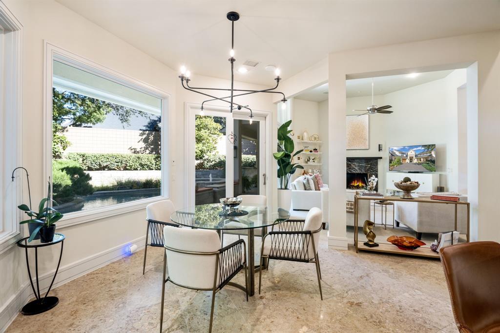 Dining area featuring large-format tile flooring, a multi-arm matte black chandelier, and expansive picture windows