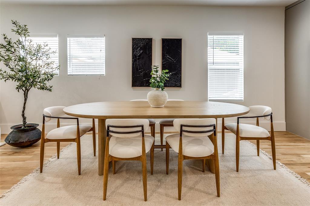 Bright room featuring wood-finish flooring, three windows with horizontal blinds, and smooth-finish neutral walls