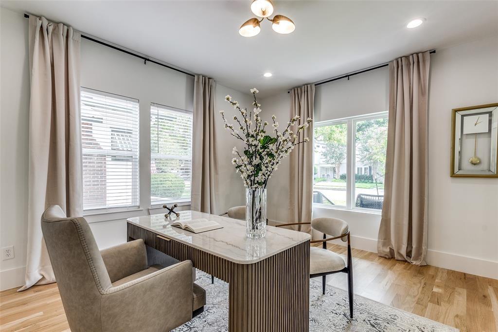 Light-filled room featuring wood flooring, multi-pane windows, and a three-light semi-flush mount ceiling fixture