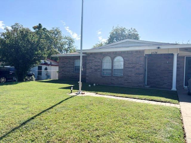 Single-story brick exterior featuring a covered front porch, arched window detailing, and a paved walkway