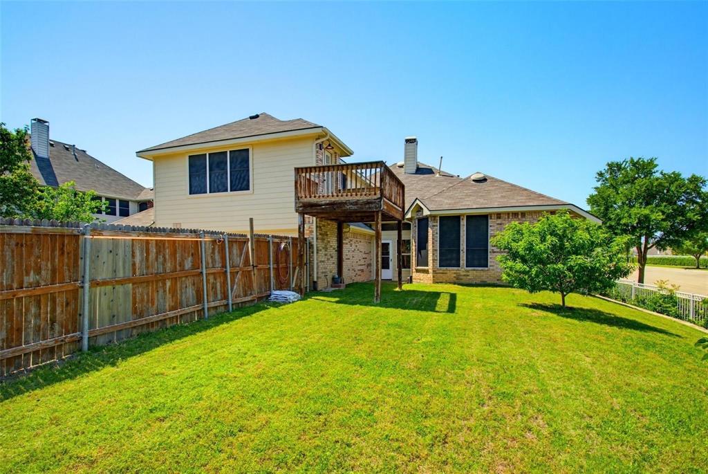 Backyard featuring a grass lawn, wood privacy fencing, and an elevated wooden deck Backyard featuring a grass lawn, wood privacy fencing, and an elevated wooden deck