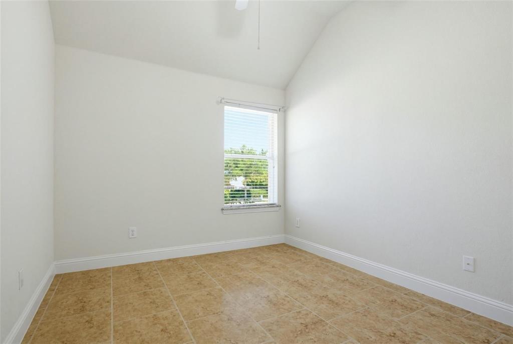 Room featuring a vaulted ceiling, neutral wall finishes, tile flooring, and a window with horizontal blinds Room featuring a vaulted ceiling, neutral wall finishes, tile flooring, and a window with horizontal blinds
