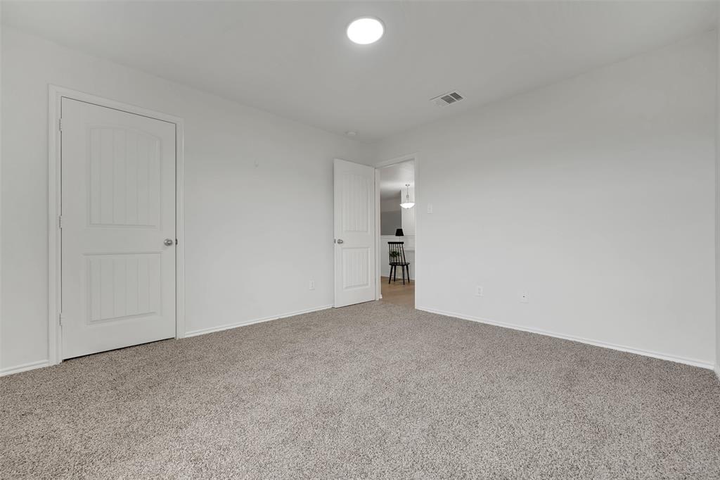 Unfurnished bedroom featuring visible vents, baseboards, and carpet