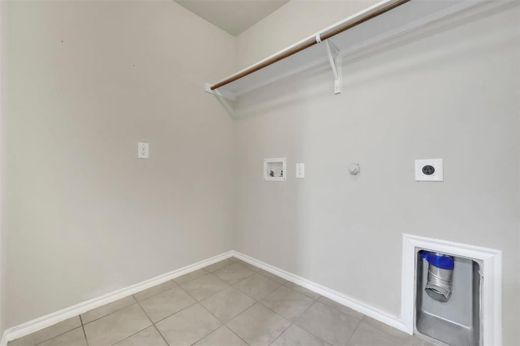 Washroom with electric dryer hookup, hookup for a washing machine, baseboards, and laundry area
