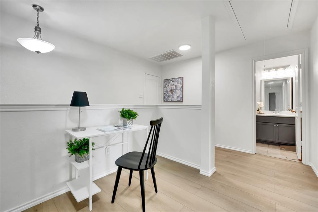 Office area with attic access, baseboards, visible vents, and light wood finished floors