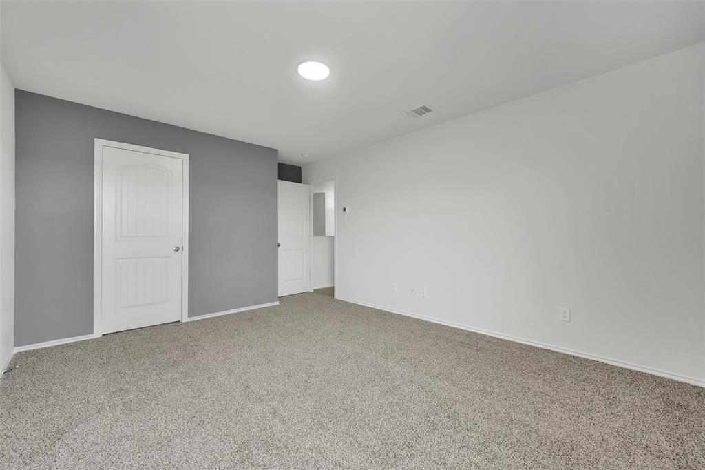 Unfurnished bedroom with visible vents, baseboards, and carpet