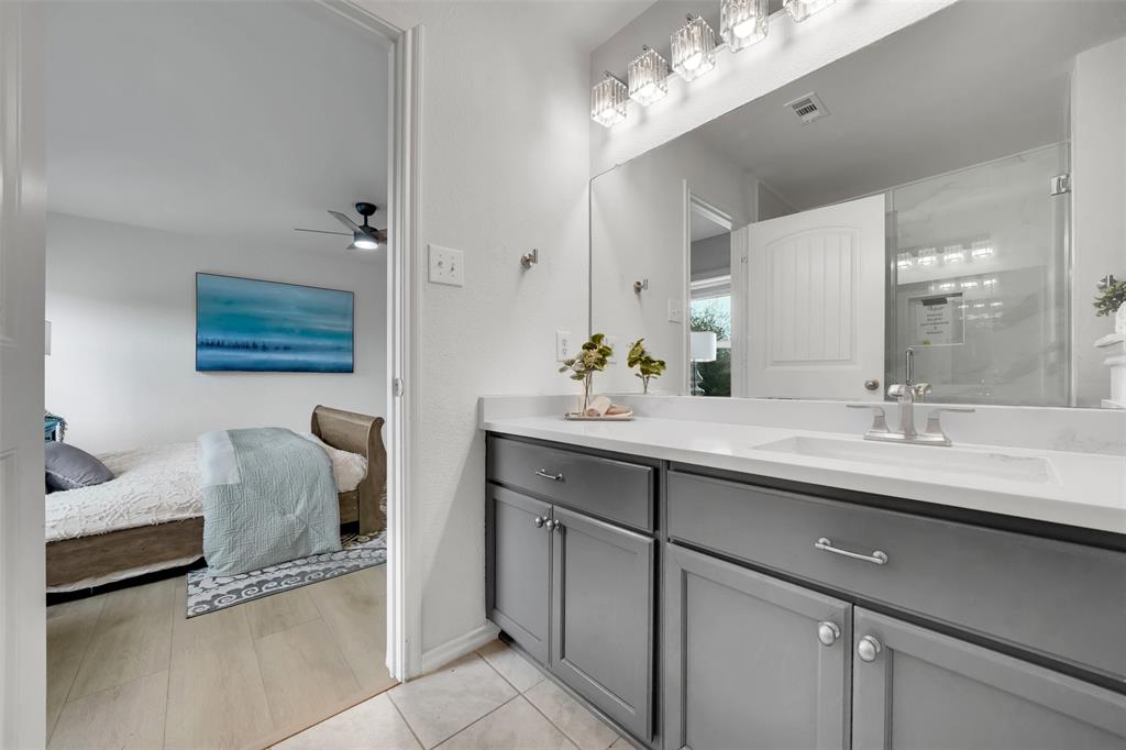 Ensuite bathroom featuring visible vents, connected bathroom, ceiling fan, tile patterned floors, and vanity