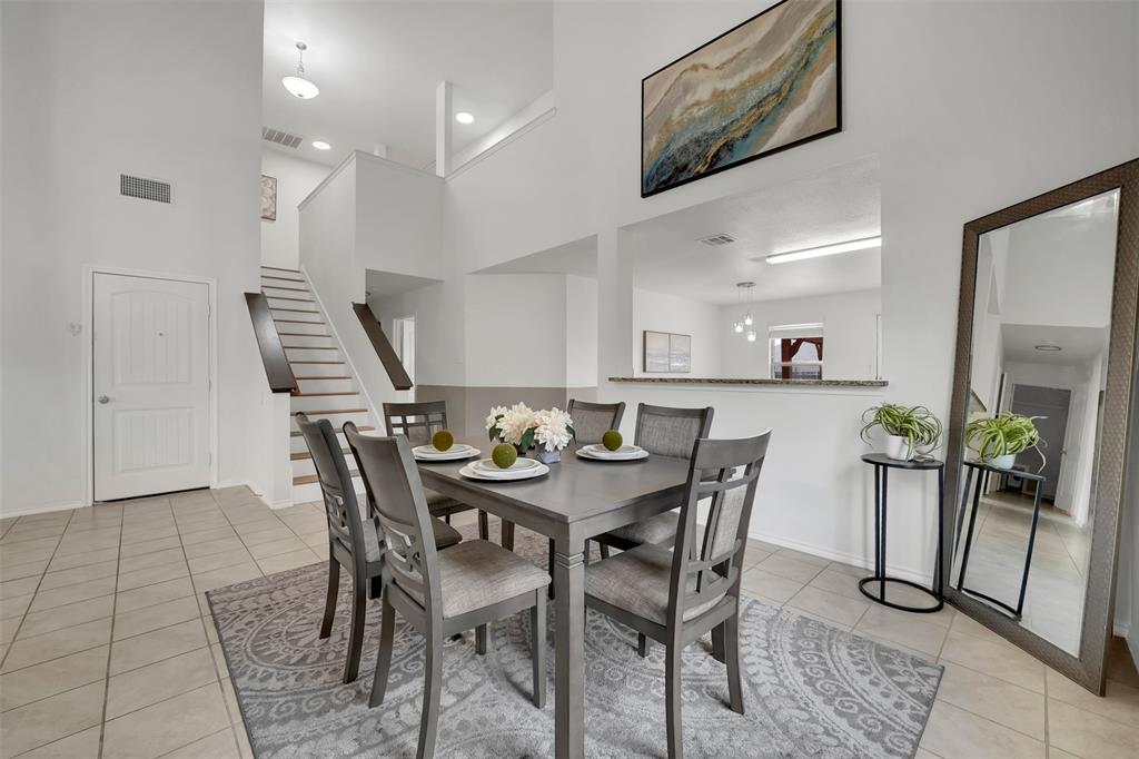 Dining room featuring a high ceiling, light tile patterned floors, and visible vents