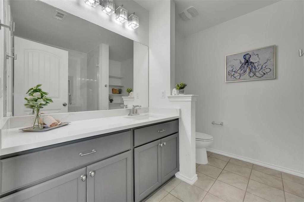 Bathroom with tile patterned floors, visible vents, toilet, baseboards, and vanity