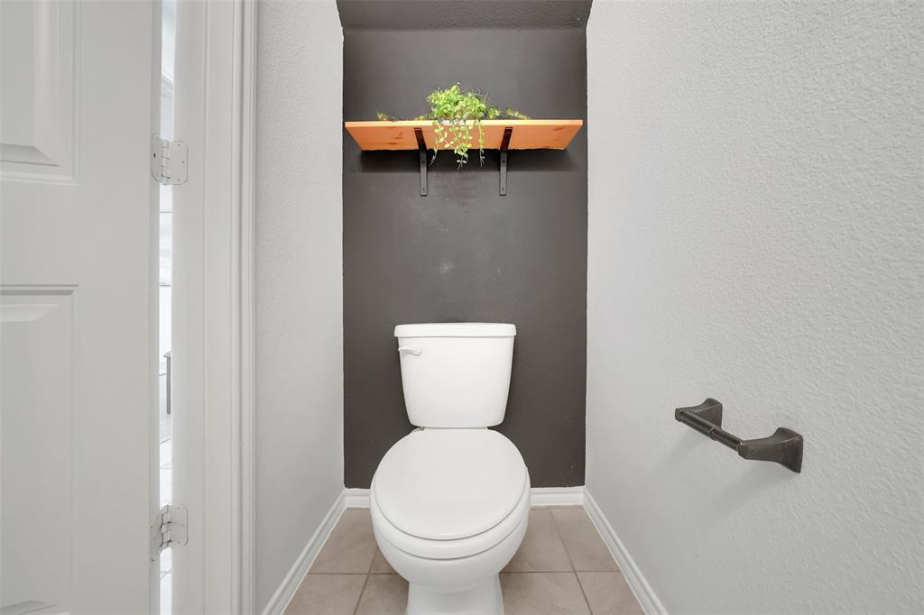 Bathroom with tile patterned floors, baseboards, and toilet