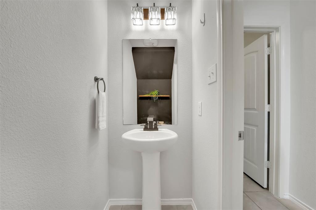Bathroom featuring tile patterned flooring and a textured wall