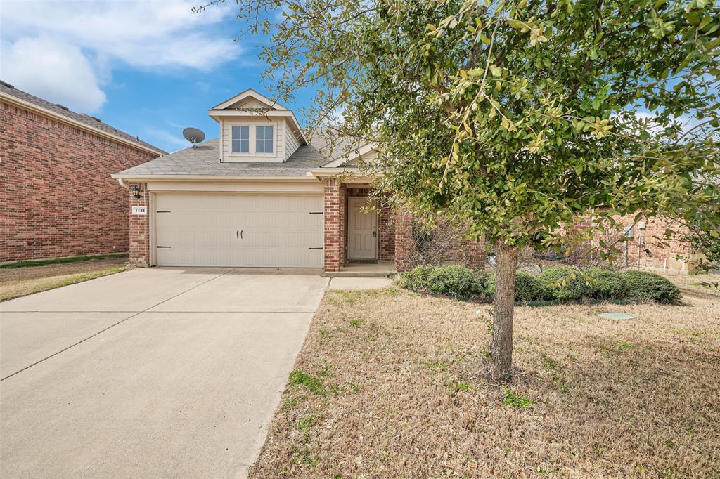 View of front of home featuring a garage, a front lawn, brick siding, and driveway