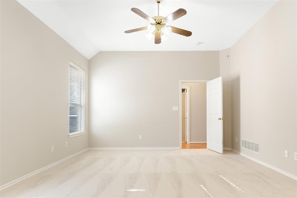 Vaulted ceiling, neutral wall tones, carpeted flooring, multi-light ceiling fan, and window featuring horizontal blinds