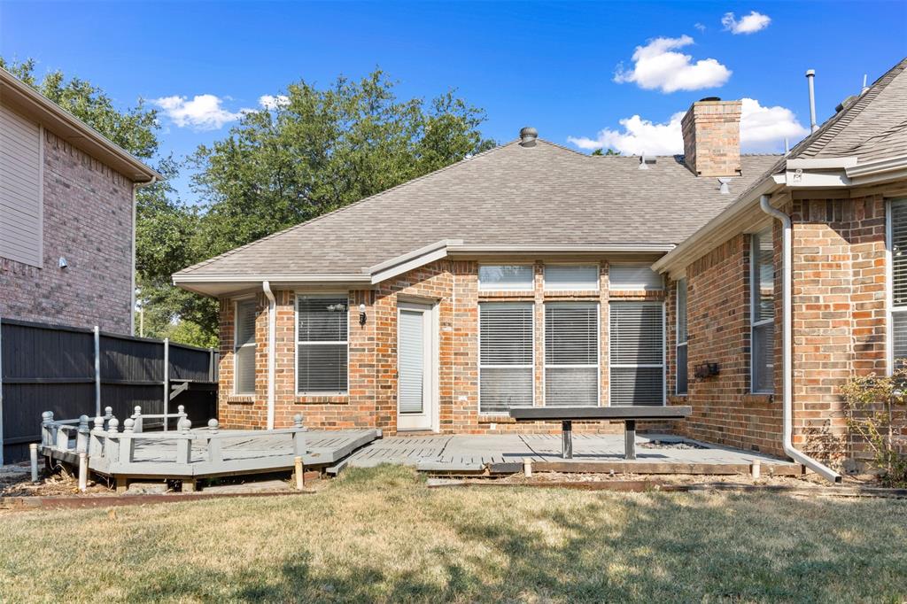 Brick exterior featuring a multi-level raised deck, integrated patio space, and masonry chimney