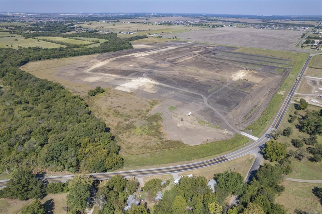 Expansive acreage featuring cleared land, dense perimeter tree lines, and paved road frontage Expansive acreage featuring cleared land, dense perimeter tree lines, and paved road frontage