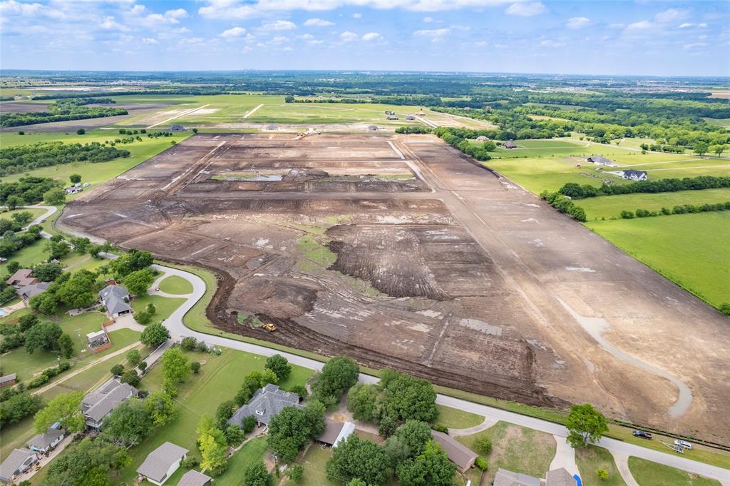 Expansive undeveloped acreage featuring cleared land, surveyed residential plots, and established paved roadway infrastructure