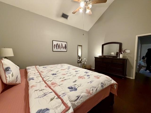 Vaulted ceiling featuring a central wood-finish ceiling fan with integrated lighting and dark-toned wood-finish flooring