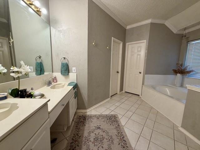 Dual-sink vanity with a solid-surface countertop, full-width wall mirror, tile flooring, and a built-in soaking tub