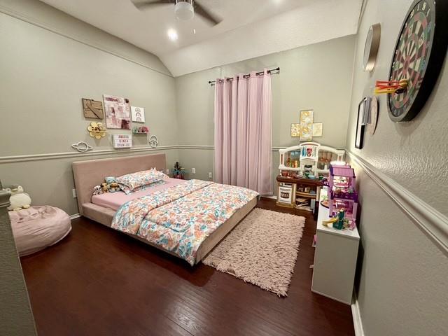 Vaulted ceiling, dark wood-finish flooring, and chair rail molding