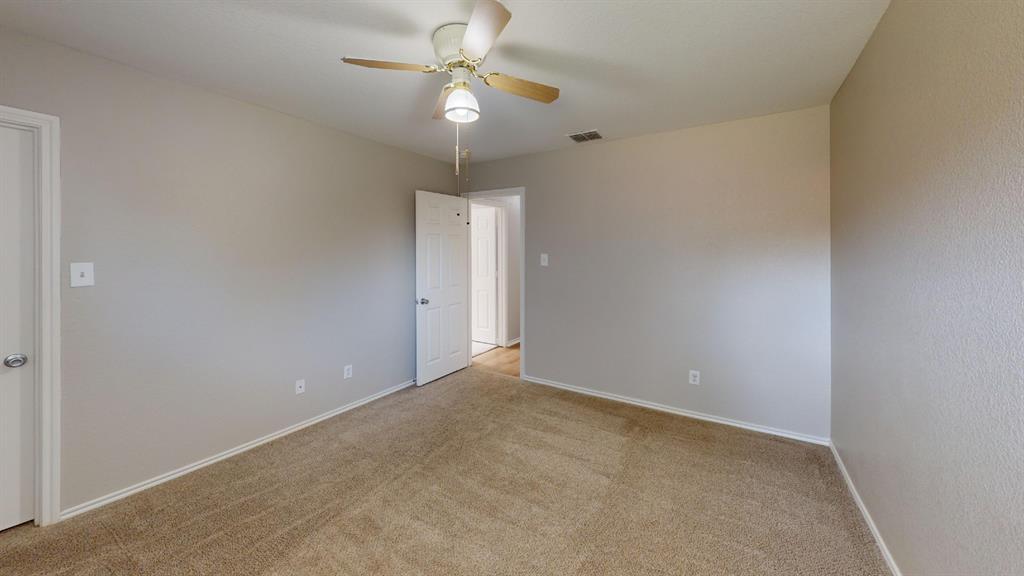 Neutral-toned walls, wall-to-wall carpeting, ceiling fan with integrated lighting, and multi-panel interior doors