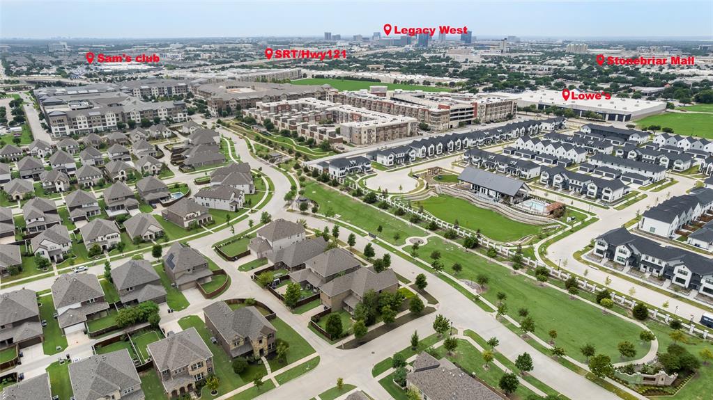 Aerial perspective of a suburban community featuring residential cul-de-sacs, expansive green spaces, a common area swimming pool, and established landscaping