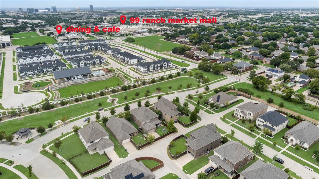Aerial perspective of a master-planned community featuring greenbelts, landscaped common areas, a central swimming pool, and proximity to retail and dining centers