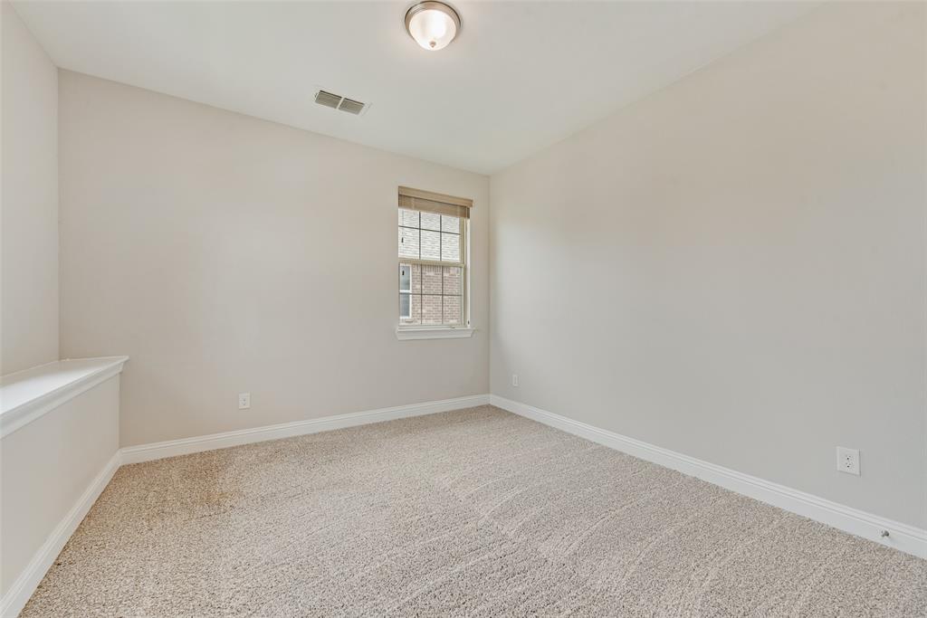Neutral-toned interior space featuring wall-to-wall carpeting, a single-hung window, and a central ceiling-mounted light fixture
