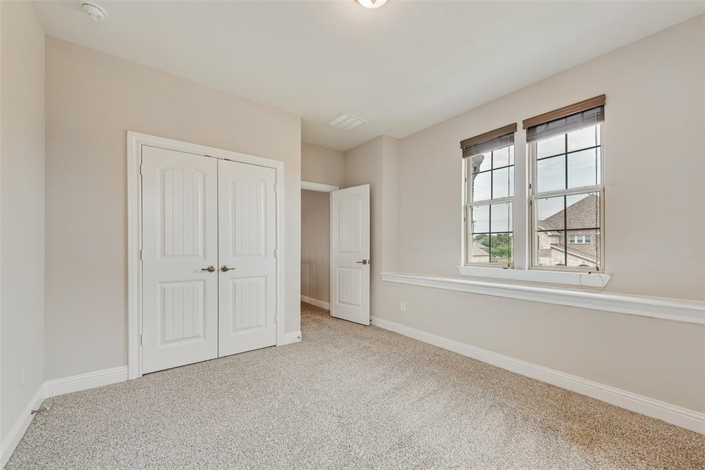 Neutral-toned interior featuring wall-to-wall carpeting, double-panel closet doors, grid-patterned windows, and chair rail molding