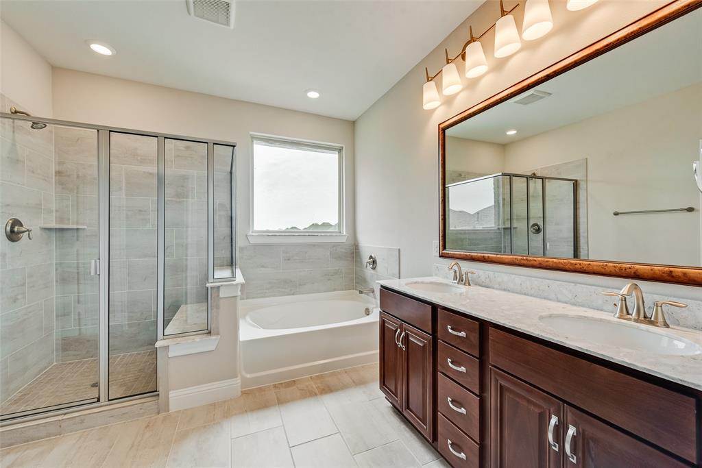 Double vanity with dark wood cabinetry, solid surface countertops, dual undermount sinks, and a large framed mirror