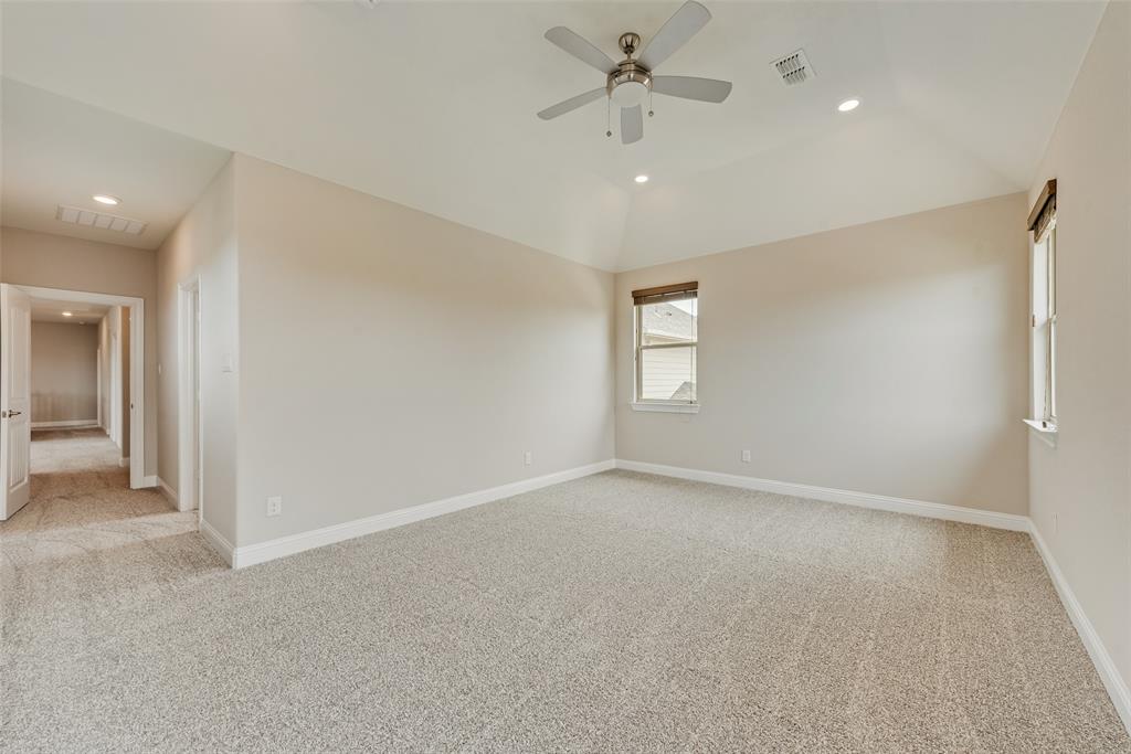 Vaulted ceiling with a central multi-blade ceiling fan, neutral wall tones, wall-to-wall carpeting, and recessed lighting