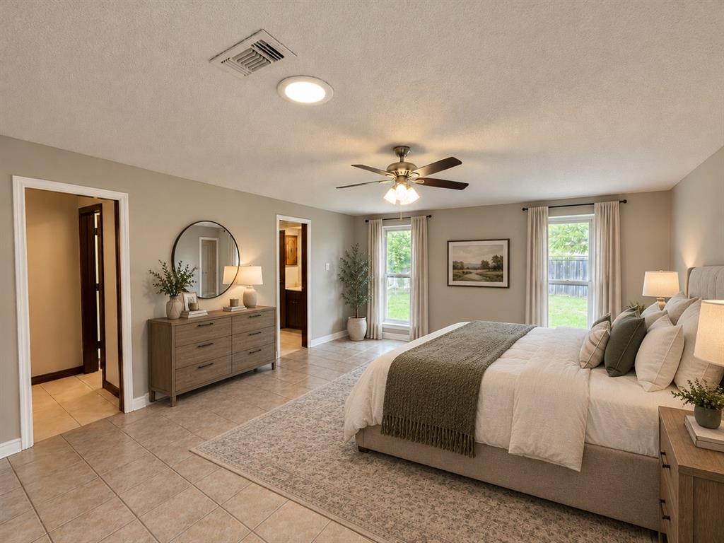 Neutral-toned interior featuring tile flooring, a multi-blade ceiling fan with integrated lighting, and multiple windows