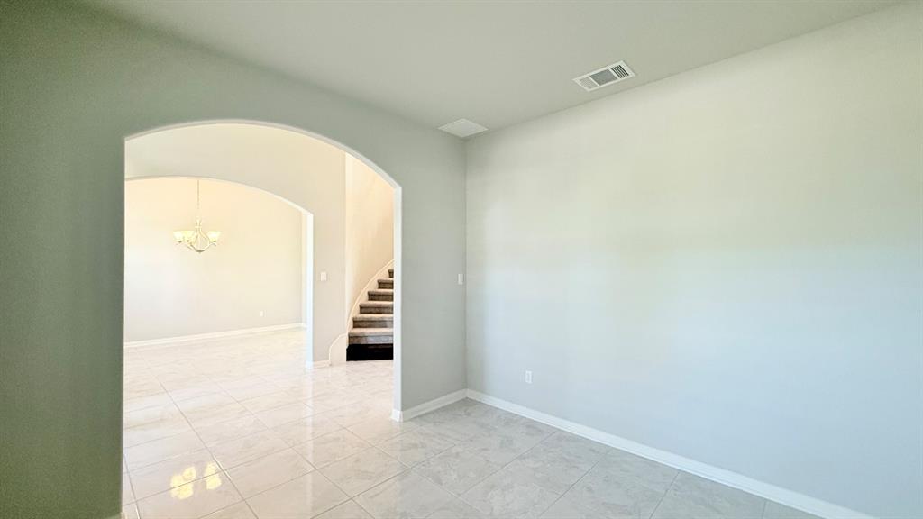 Interior featuring polished tile flooring, neutral wall tones, and a large architectural archway