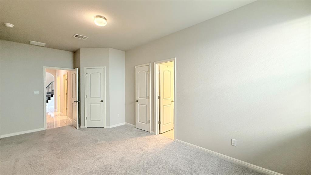 Neutral interior space featuring wall-to-wall carpeting, raised-panel interior doors, and a ceiling-mounted light fixture
