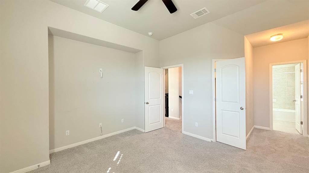 Vaulted ceilings featuring a black ceiling fan, recessed wall alcove, neutral wall color, and wall-to-wall carpeting