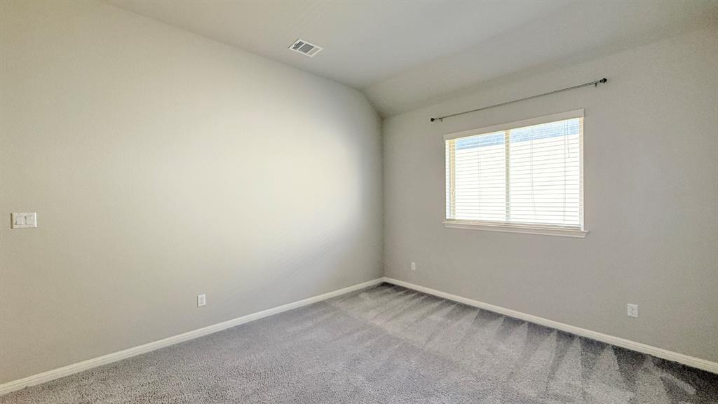 Neutral-toned room featuring high vaulted ceilings, wall-to-wall carpeting, and a window with horizontal blinds