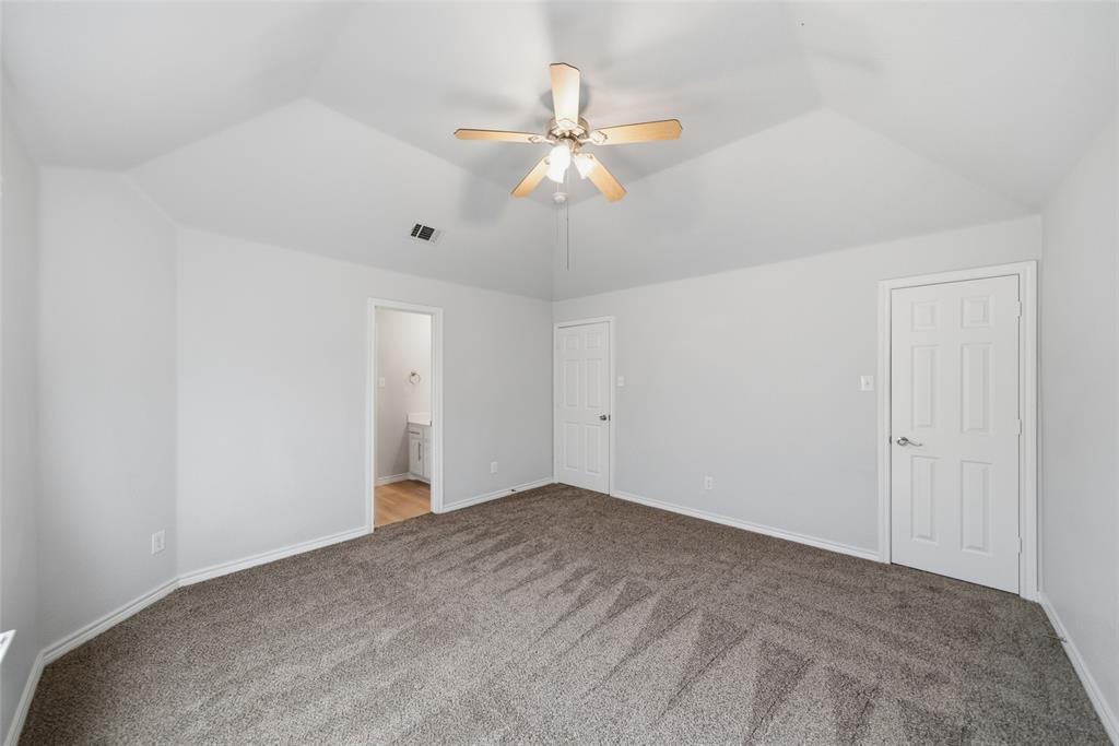 Vaulted ceilings featuring a central ceiling fan with integrated lighting and wall-to-wall carpeting