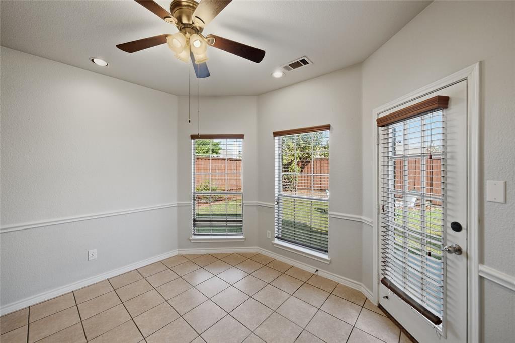 Ceramic tile flooring, bay-style window configuration, recessed lighting, ceiling fan with integrated light fixture, and glass-paneled exterior door
