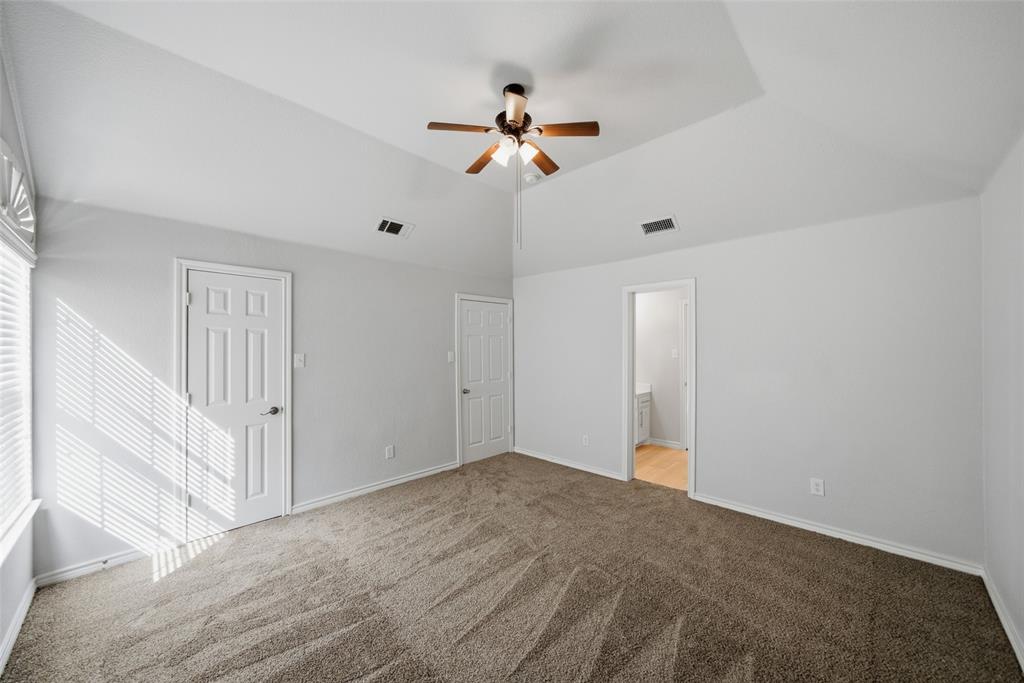 Vaulted ceilings featuring a multi-blade ceiling fan and neutral wall-to-wall carpeting